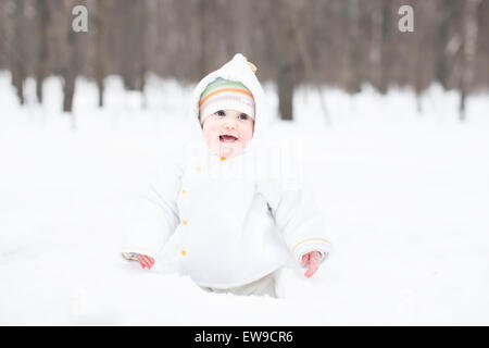 Kleine lustige Baby Graben im Schnee Stockfoto