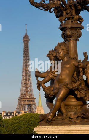 Cherub Statue am Laternenpfahl entlang Pont Alexndre III mit Eiffelturm über Paris, Frankreich Stockfoto