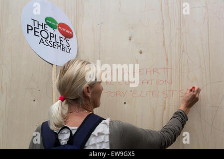 London, UK. 20. Juni 2015. Eine Frau schreibt eine Protest-Meldung über den Zustand des Bildungssystems an der Wand. Demonstranten nehmen Teil an der Demonstration Ende Sparmaßnahmen jetzt im Zentrum von London. Bildnachweis: Bas/Alamy Live-Nachrichten Stockfoto