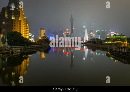 Beleuchtete Stadt und Brücke auf dem Wasser Stockfoto