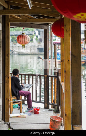 Künstler malt Gondeln auf dem Kanal in der historischen, malerischen Wasserstadt Zhouzhuang, China Stockfoto