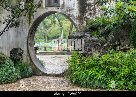 Blick auf den Garten durch eine kreisförmige Tür in Suzhou, China Stockfoto