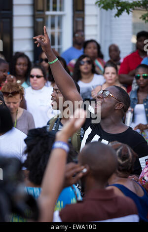 Trauernden beten und singen Spirituals an einem improvisierten Denkmal außerhalb der historischen Mutter Emanuel African Methodist Episcopal Church 20. Juni 2015 in Charleston, South Carolina. Früher in der Woche getötet ein weißes Supremacist Schütze 9 Mitglieder in der historisch schwarze Kirche. Stockfoto