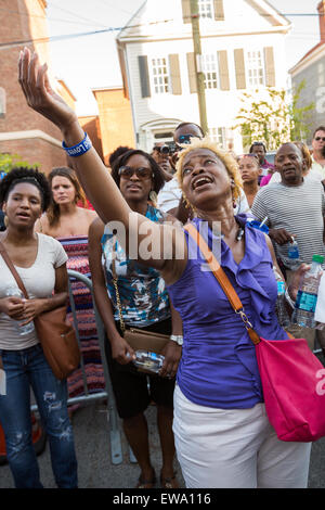 Trauernden beten und singen Spirituals an einem improvisierten Denkmal außerhalb der historischen Mutter Emanuel African Methodist Episcopal Church 20. Juni 2015 in Charleston, South Carolina. Früher in der Woche getötet ein weißes Supremacist Schütze 9 Mitglieder in der historisch schwarze Kirche. Stockfoto