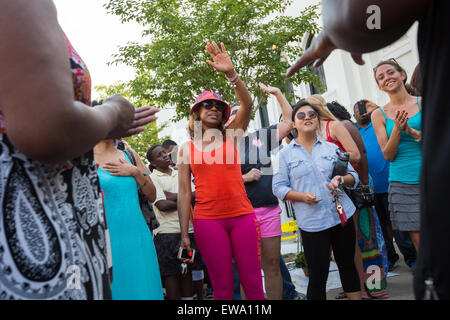 Trauernden beten und singen Spirituals an einem improvisierten Denkmal außerhalb der historischen Mutter Emanuel African Methodist Episcopal Church 20. Juni 2015 in Charleston, South Carolina. Früher in der Woche getötet ein weißes Supremacist Schütze 9 Mitglieder in der historisch schwarze Kirche. Stockfoto