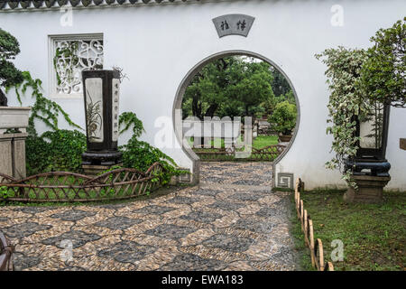 Blick auf den Garten durch eine kreisförmige Tür in Suzhou, China Stockfoto