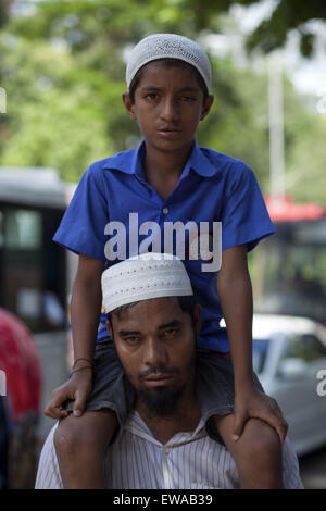 Dhaka, Bangladesch. 20. Juni 2015. DHAKA, Bangladesch-20. Juni: ein Vater tragen sein Gehirn Krebs betroffenen Sohn auf seine Schulter in der Straße und bekommen Hilfe von Leuten für die Behandlung seines Sohnes im 20. Juni 2015. © Zakir Hossain Chowdhury/ZUMA Draht/Alamy Live-Nachrichten Stockfoto