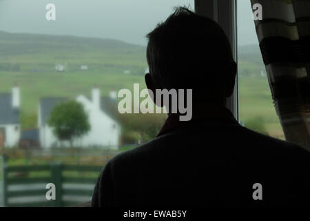 Silhouette-Mann aus dem Fenster schauen. Zurück zur Kamera, ländliche Ansicht nicht mehr wiederzuerkennen. Stockfoto