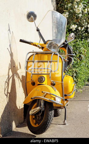 gelbe Retro-Motorrad stehen gegen die Wand Stockfoto