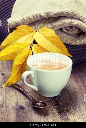 Tasse Kaffee, warme wollene Sachen Herbst Blätter auf einem hölzernen Hintergrund (Vintage style, Muskelaufbau) Stockfoto