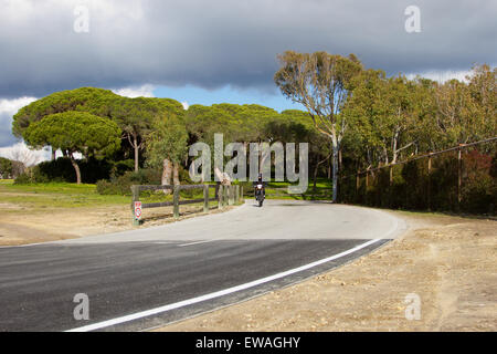 Ein anonyme Mann fährt ein Motorrad auf den Nebenstraßen von Rota, Spanien. Stockfoto