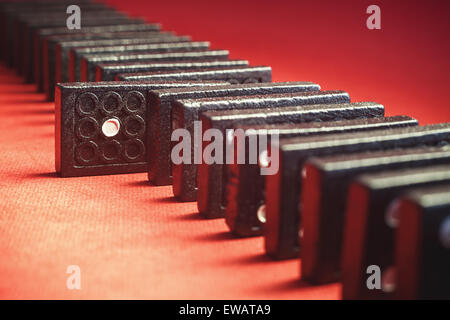 Konzeptionellen Zusammensetzung der Dominosteine mit ausgewählten, eines davon mit Nummer eins, roten Hintergrund in Unschärfe. Stockfoto