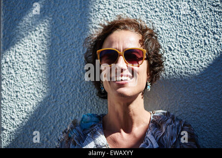 Eine modische Reife Frau lächelnd mit Sonnenbrille auf. Stockfoto