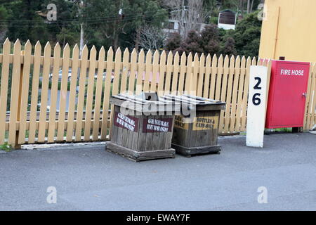 Klassische hölzerne Mülleimer in der Nähe von Holzzaun Stockfoto