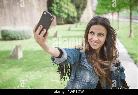Junge Brünette Frau, die einen Selfie im freien Stockfoto