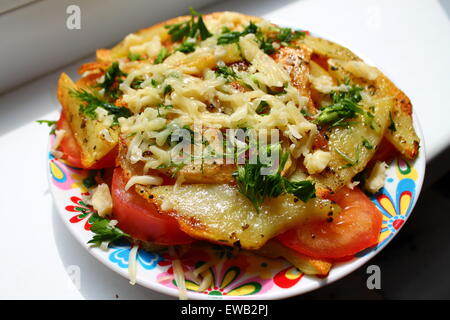 appetitlich Kartoffelscheiben goldene junge auf rote Tomate mit Käse und grün Stockfoto