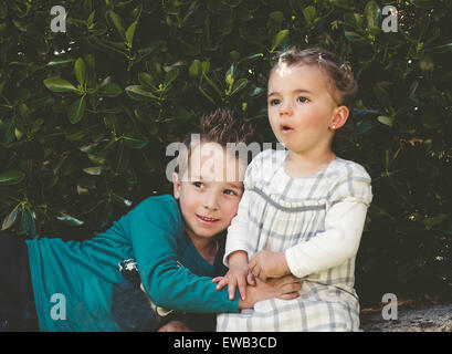 Jungen und Mädchen Portrait mit Pflanzen im Hintergrund Stockfoto