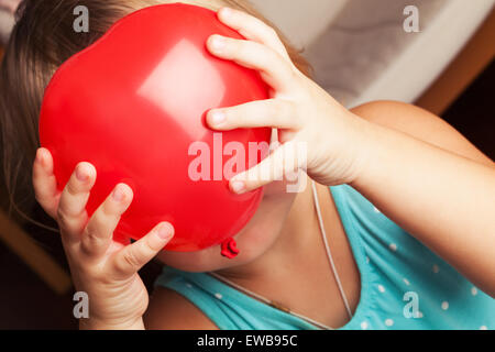 Kaukasische Mädchen hält kleine rote herzförmige Ballons in ihren Händen Stockfoto