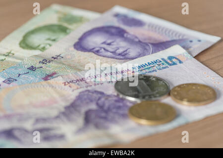 Chinesische Renminbi (Yuan auch genannt) Banknoten und Münzen auf einem Holztisch Stockfoto