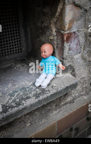 Puppe sitzt auf der Fensterbank Stockfoto