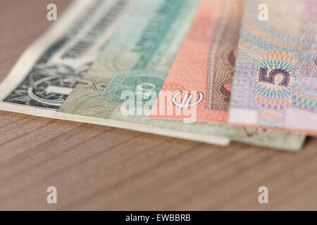 Chinesische Renminbi, Euro, VAE-Dirham und uns-Dollar-Banknoten auf Holztisch Stockfoto