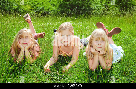 glückliche Kinder liegen auf dem grünen Rasen Stockfoto