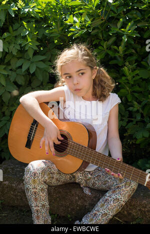 Sieben Jahre altes Mädchen im Freien eine spanische Gitarre Stockfoto