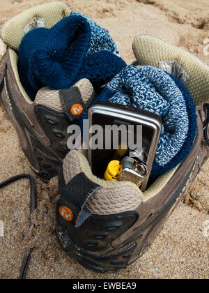 Schuhe in den Sand am Strand, mit Handy und Zigarettenanzünder Stockfoto