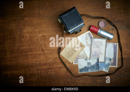Alte Vintage retro-Filmkamera und schwarz-weiß-Fotos auf dem alten Holztisch, Bilder, Erinnerungen Stockfoto