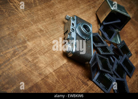 Vintage alte Retro-Filmkamera und alten leeren Frame Papierfotos auf hölzernen Hintergrund. Nostalgische Stil Bild, Erinnerungen, Stockfoto