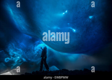 Ein Mann untersucht die eisige Decke eine Eisturm über einem Vulkanschlot auf Mount Erebus, Antarktis. Stockfoto