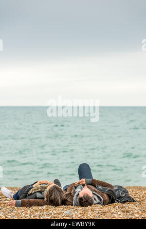 Ein paar entspannen Sie am Strand an der Küste in Brighton, East Sussex, England. Stockfoto