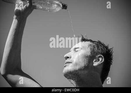 Foto von einem Mann, der hat Gesicht ist mit Wasser bedeckt. Schönen Himmel im Hintergrund. Stockfoto