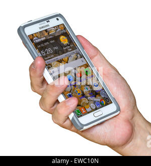 Mann mit Handy Samsung Galaxy Note 4 (mit einer Schutzhülle) in der Hand, auf einem weißen Hintergrund. Stockfoto