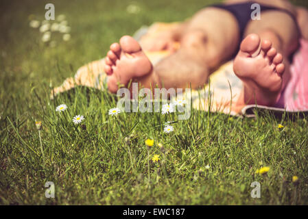 Foto eines jungen Mannes, der zum Sonnenbaden ist. Viel Grün im Vordergrund Stockfoto