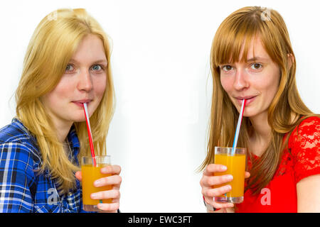Zwei kaukasischen Teenager Freundinnen trinken Orangensaft isoliert auf weißem Hintergrund Stockfoto