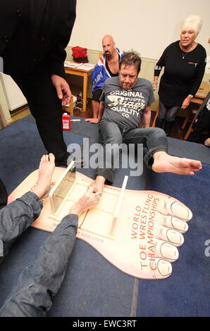 Die Teilnehmer kämpfen bei den Toe Wrestling Championships im Dorf Fenny Bentley in Derbyshire, England, gegen ihn Stockfoto