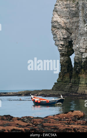 Malerische Aussicht im sonnigen Sommer, blauer Himmel, ruhiges Meer & Holzboot vertäut off-Shore-durch Bogen in hoch aufragenden Kreidefelsen. Flamborough, Yorkshire Coast, UK. Stockfoto