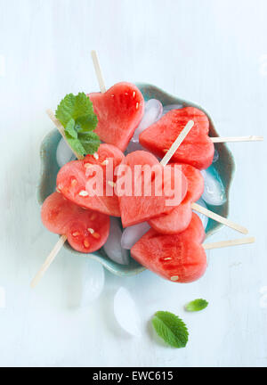 Wassermelone-Pops. Wassermelone-Scheiben in Herz-Form-Stücke schneiden. Stockfoto