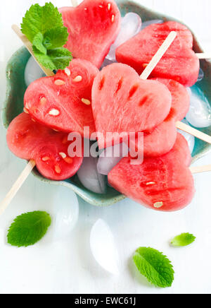 Wassermelone-Pops. Wassermelone-Scheiben in Herz-Form-Stücke schneiden. Stockfoto