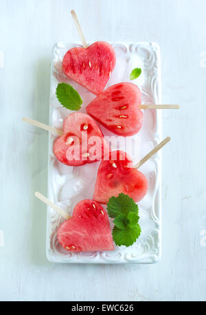 Wassermelone-Pops. Wassermelone-Scheiben in Herz-Form-Stücke schneiden. Stockfoto