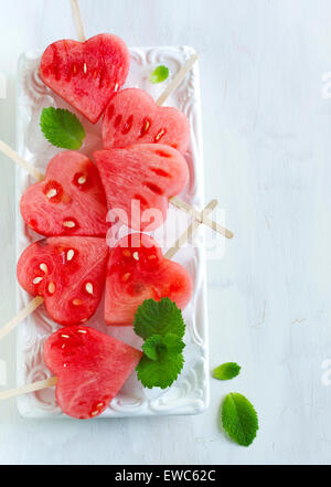 Wassermelone-Pops. Wassermelone-Scheiben in Herz-Form-Stücke schneiden. Stockfoto