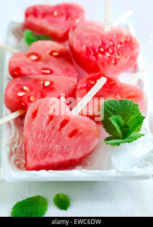 Wassermelone-Pops. Wassermelone-Scheiben in Herz-Form-Stücke schneiden. Stockfoto