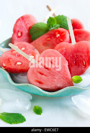 Wassermelone-Pops. Wassermelone-Scheiben in Herz-Form-Stücke schneiden. Stockfoto