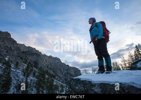 Eine Frau Wanderungen im Morgengrauen zu einem Eisklettern in Blodgett Canyon, Bitterroot Mountains, Montana. Stockfoto