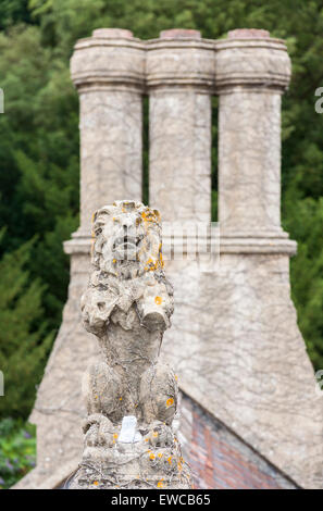 Bröckelt Statue Löwen und drei Dreibettzimmer Schornsteine, Tyntesfield, einem viktorianischen Neugotik Haus und Anwesen in der Nähe von Wraxall, North Somerset, England Stockfoto