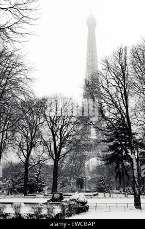 Blick auf den Eiffelturm unter dem Schnee von einem Garten im Winter Stockfoto