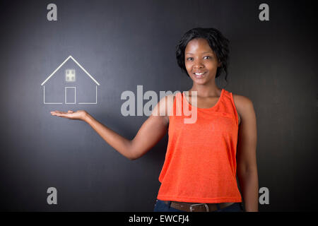 South African oder afroamerikanische Frau Lehrer, Student, Verkäuferin oder Geschäftsfrau vor schwarzem Hintergrund halten Haus Stockfoto