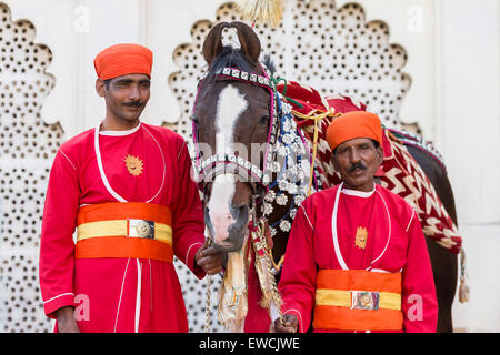 Marwari Pferde mit zwei Pfleger aufwendig dekoriert. Teilnehmer am Holi-Festival im City Palace, Udaipur, Indien Stockfoto