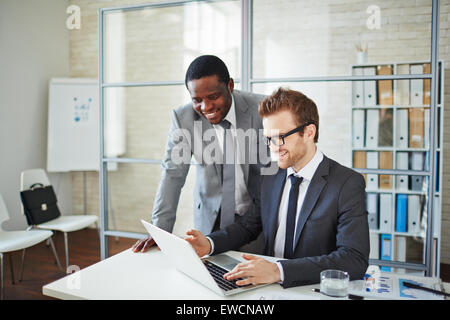 Glücklich junger Geschäftsmann seine Kollegen Informationen über neues Projekt anzeigen Stockfoto